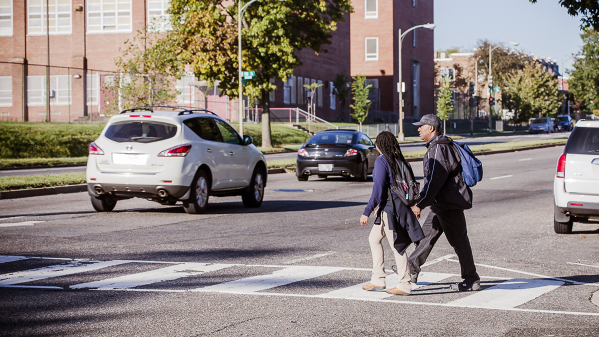 A man and woman crossing the street