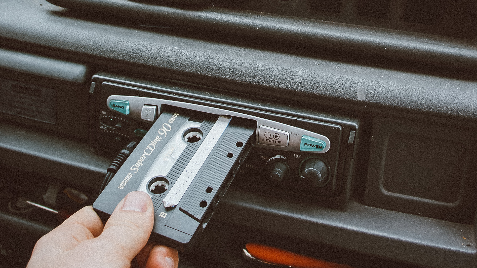 hand placing cassette into car slot