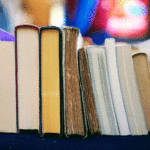 Stack of books laying on a table.