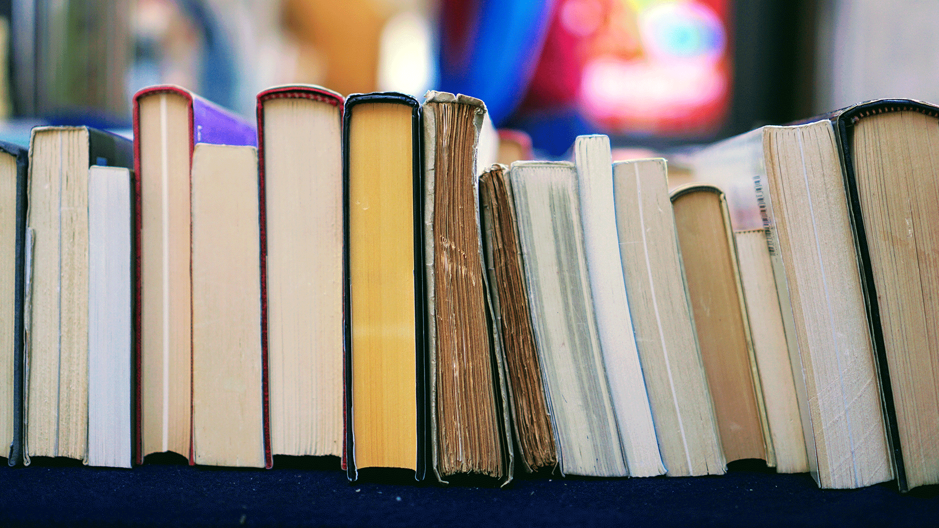 Stack of books laying on a table.