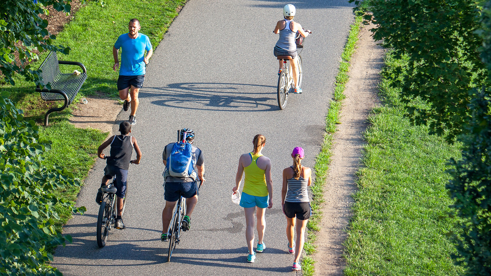 People jogging and biking on a crowded trail