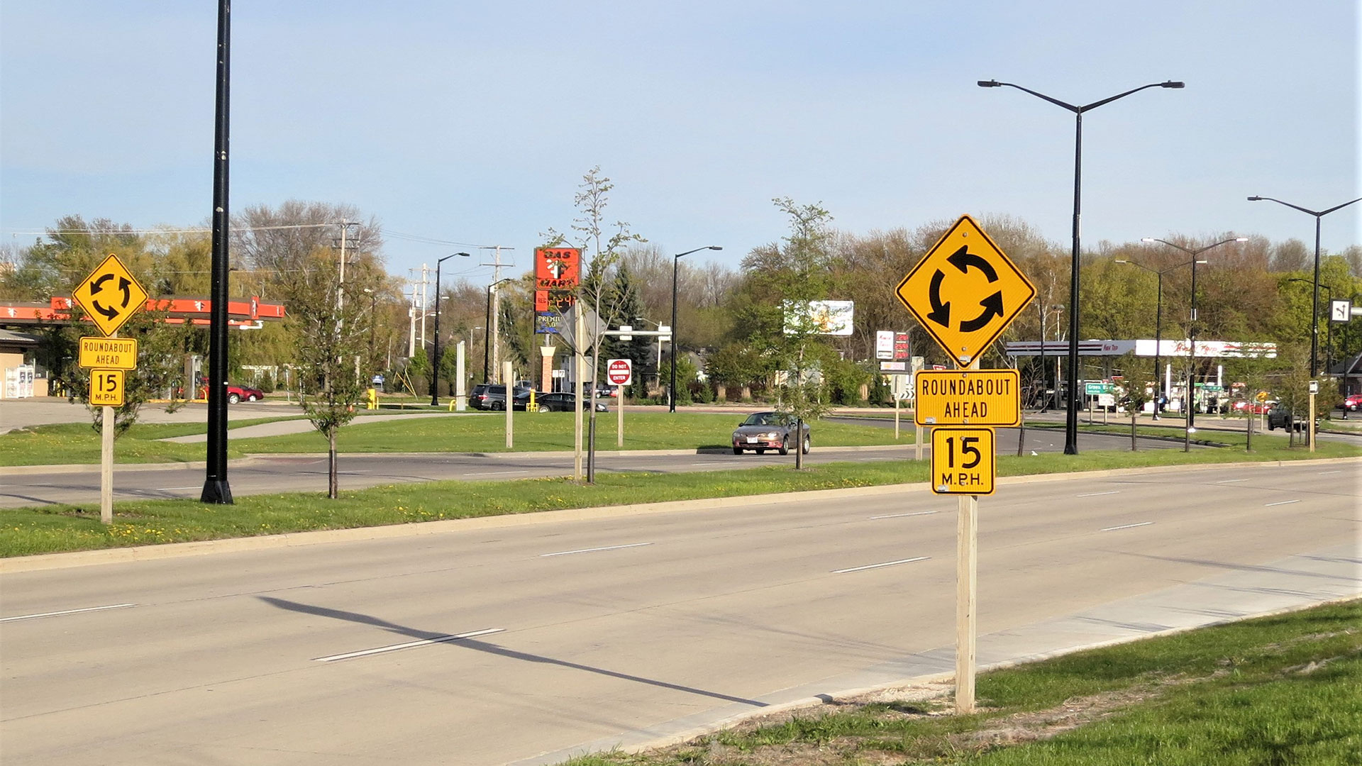 Picture of two signs that say "roundabout ahead"