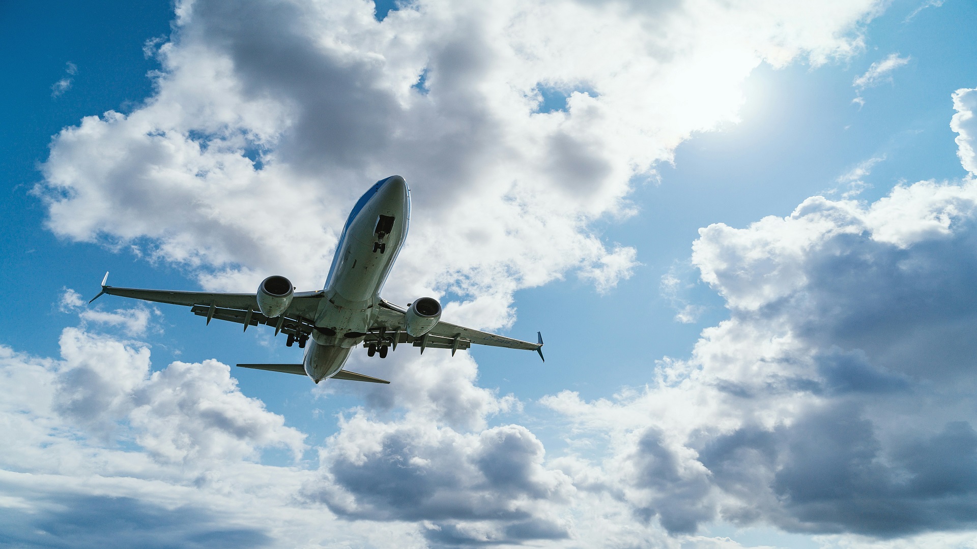 Airplane in sky surrounded by clouds.