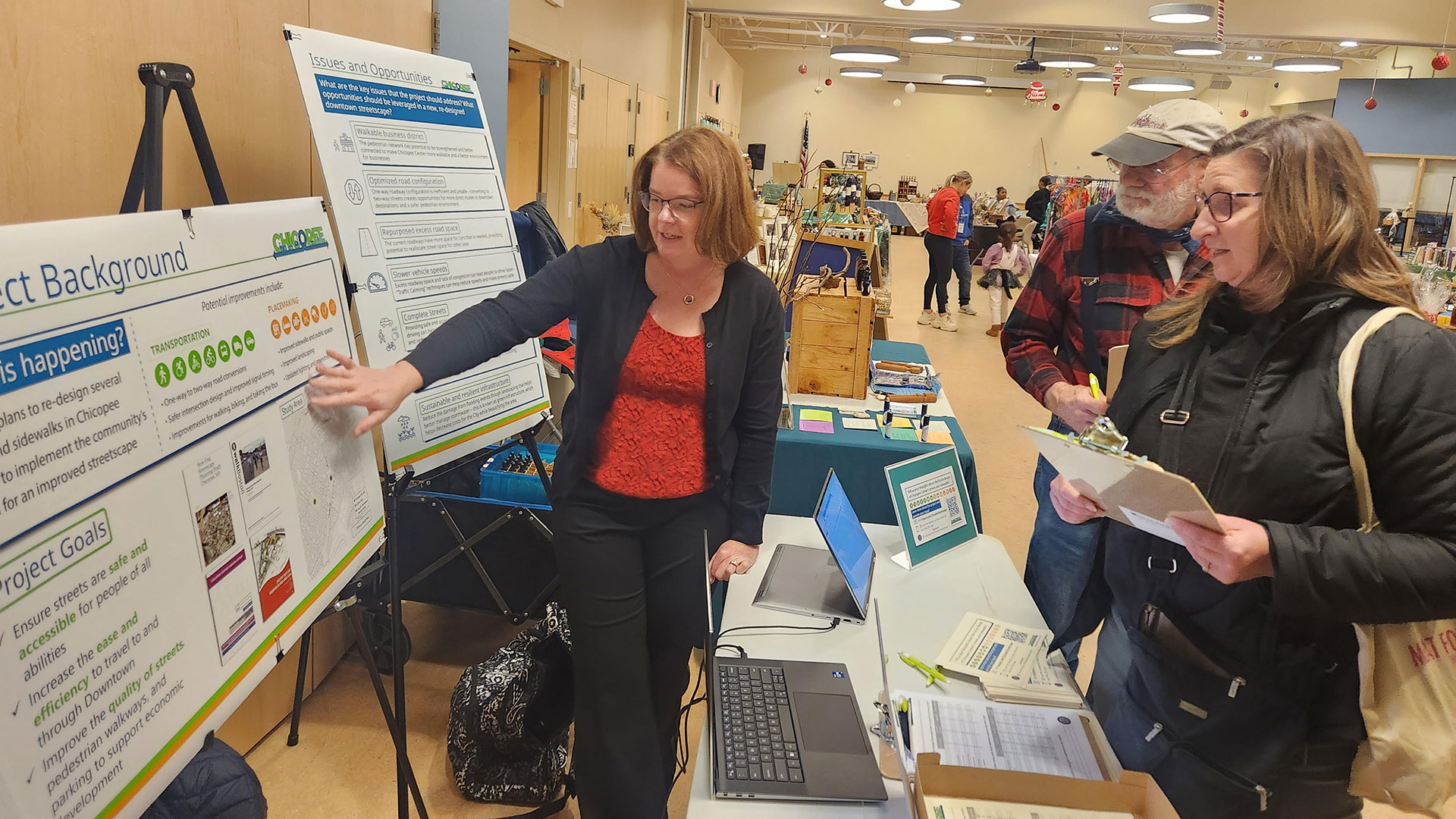 Christi Apicella points to a board while talking to a community member
