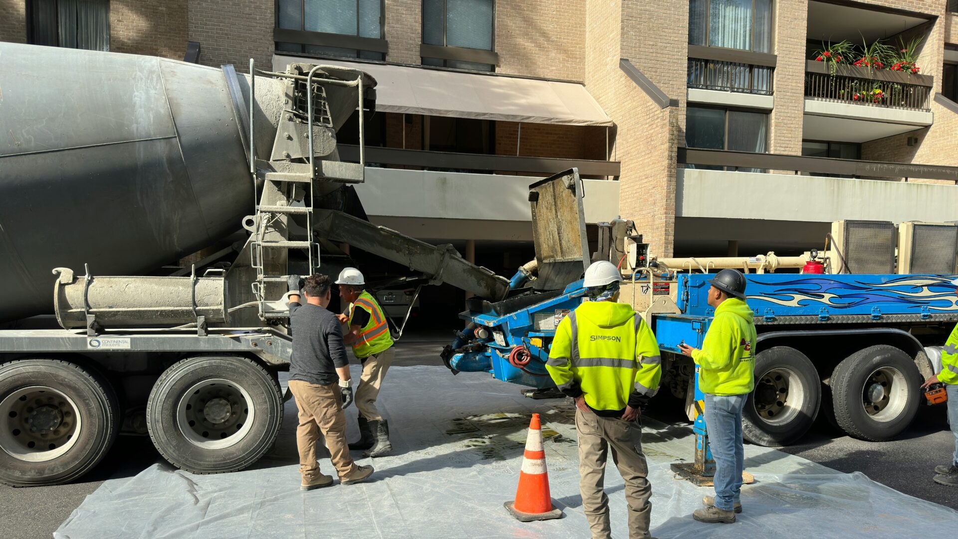 a group of men standing next to a cement truck