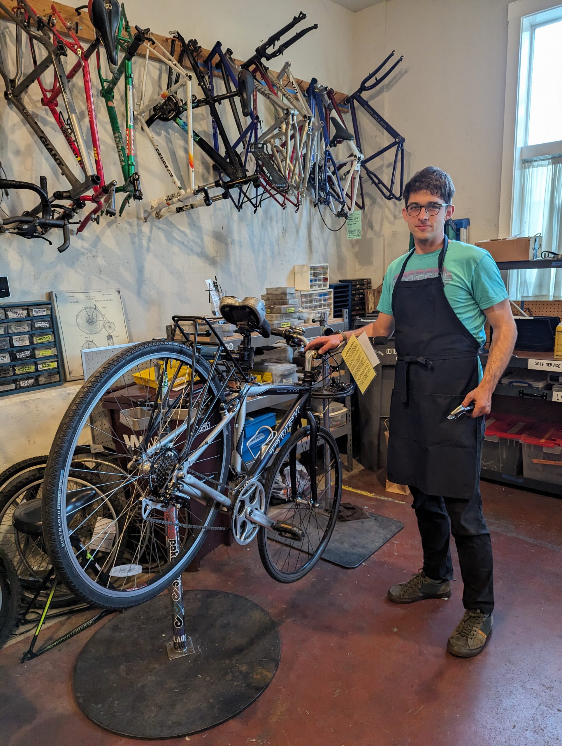 Man standing in front of bike he is repairing