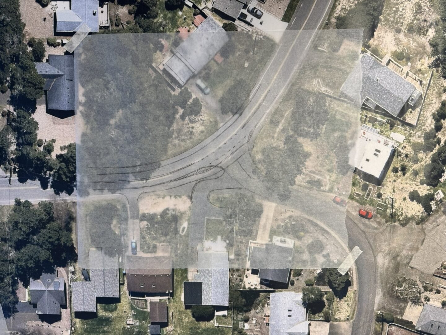 An aerial image of the neighborhood, over which has been set a sketch of a new intersection configuration.