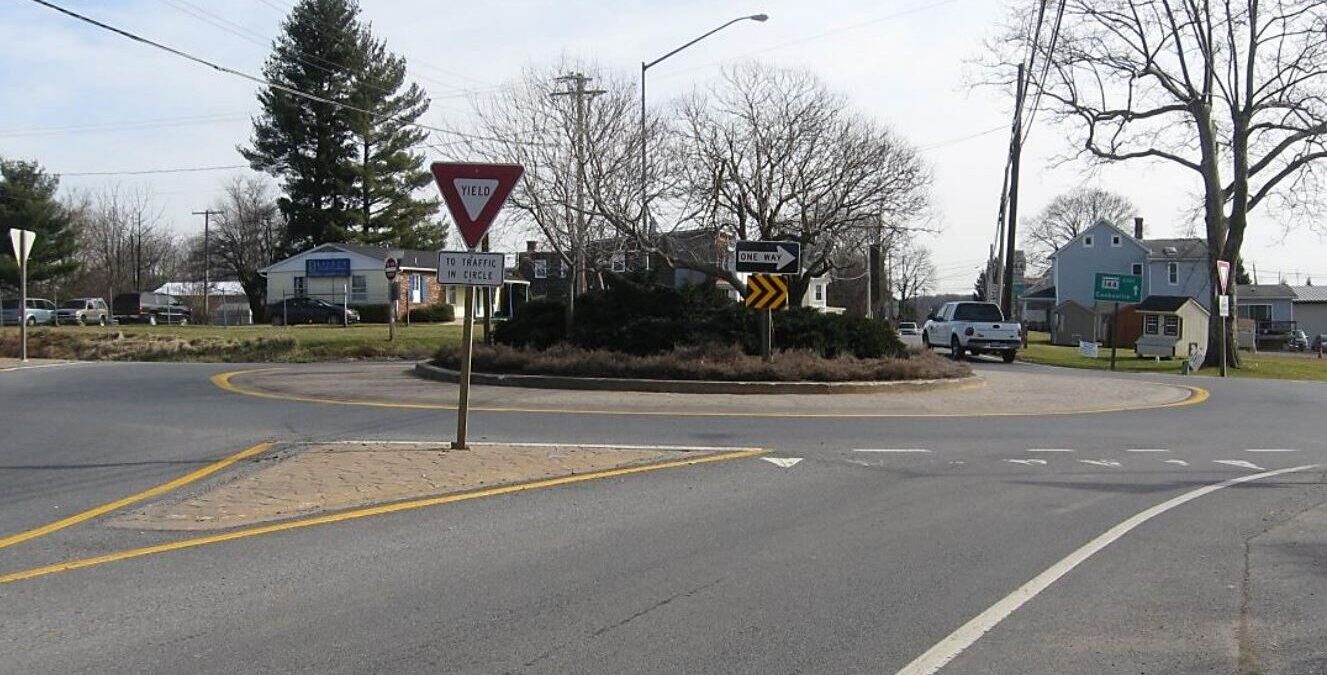 A street-view of a roundabout with a yield sign