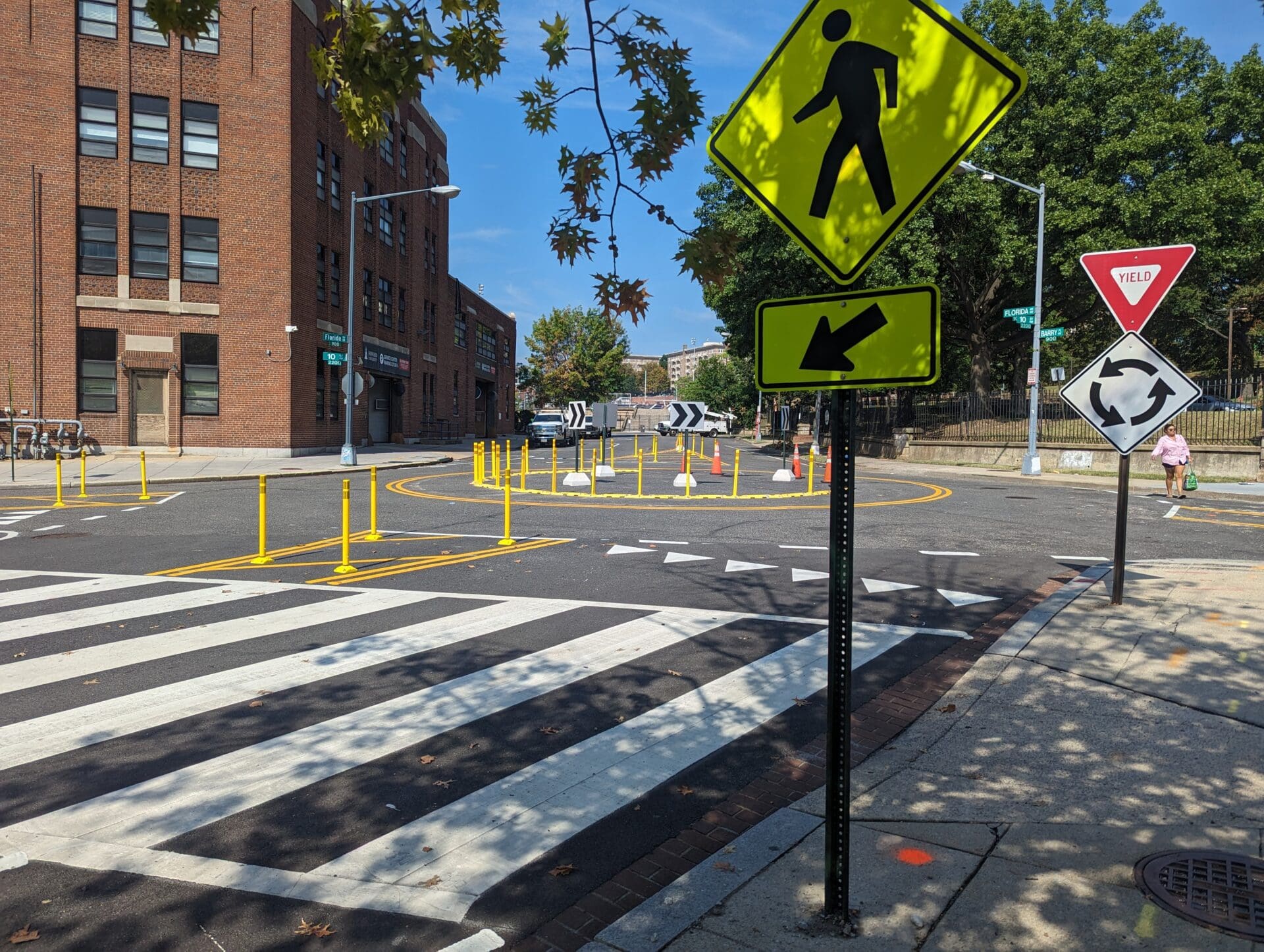 A flex posts divert traffic at a quick-build roundabout at the intersection of three streets.