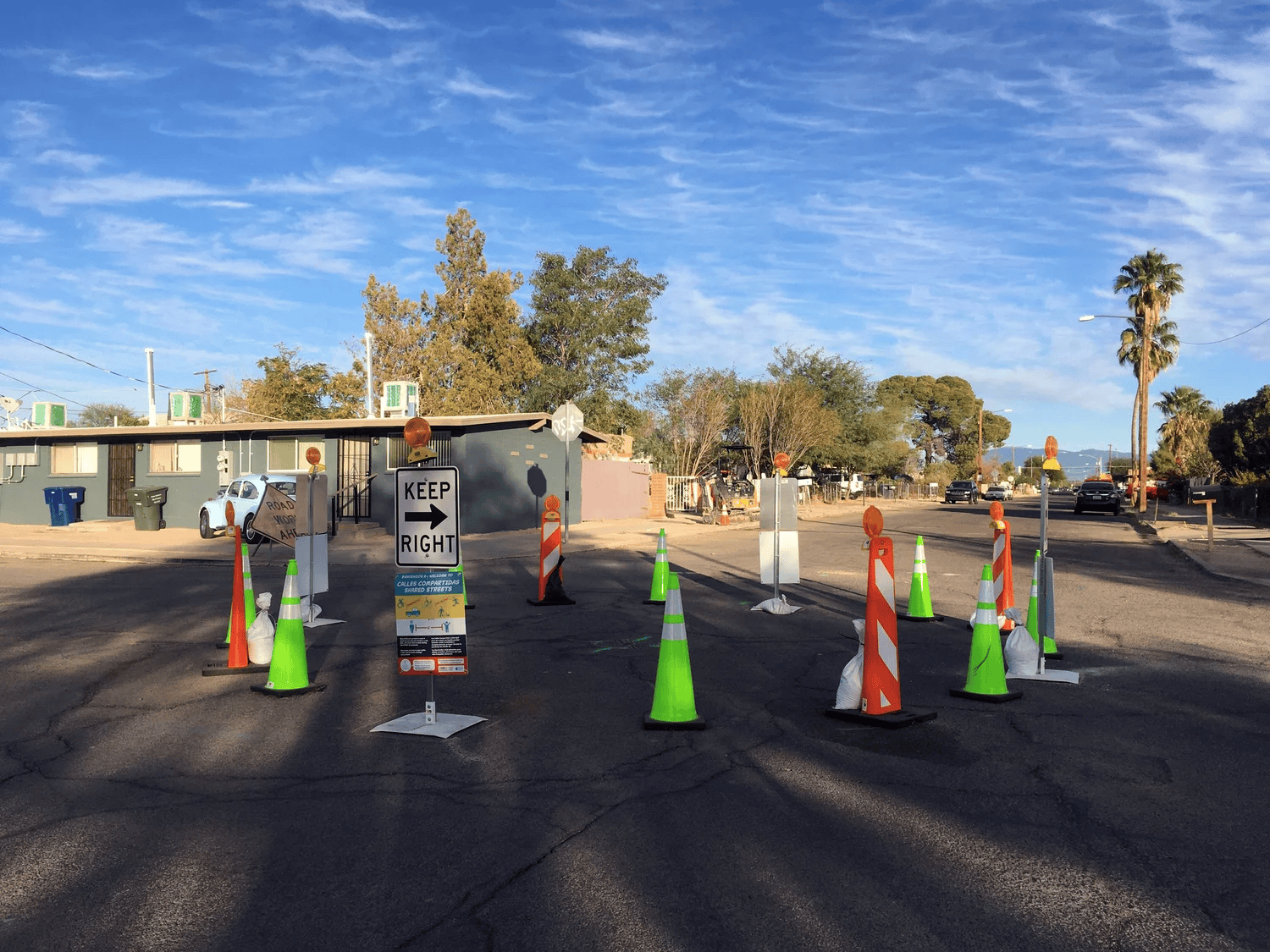 Neon cones and signs form a circle in the middle of an intersection.