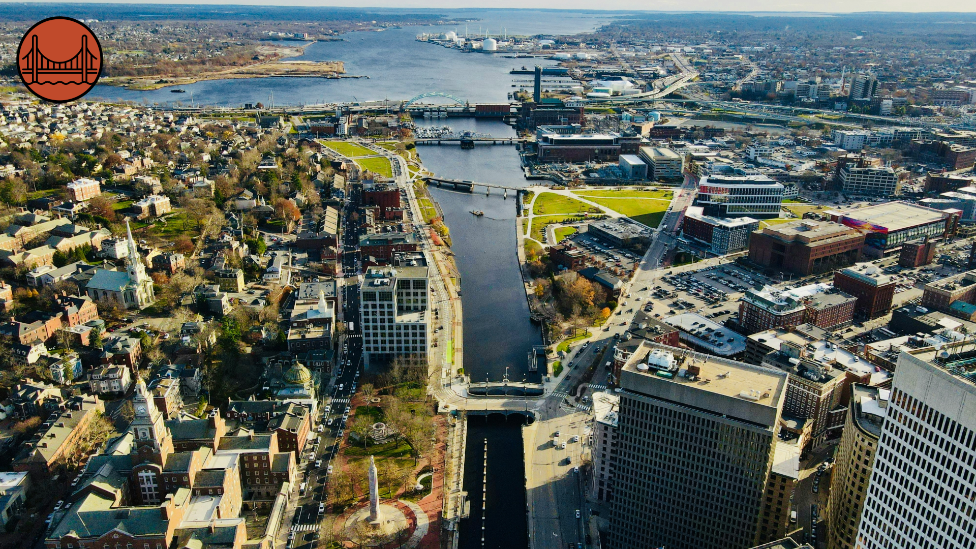 An aerial photograph of Providence, Rhode Island. The photo demonstrates the many bridges that span the river throughout the urban area on the way to the harbor.