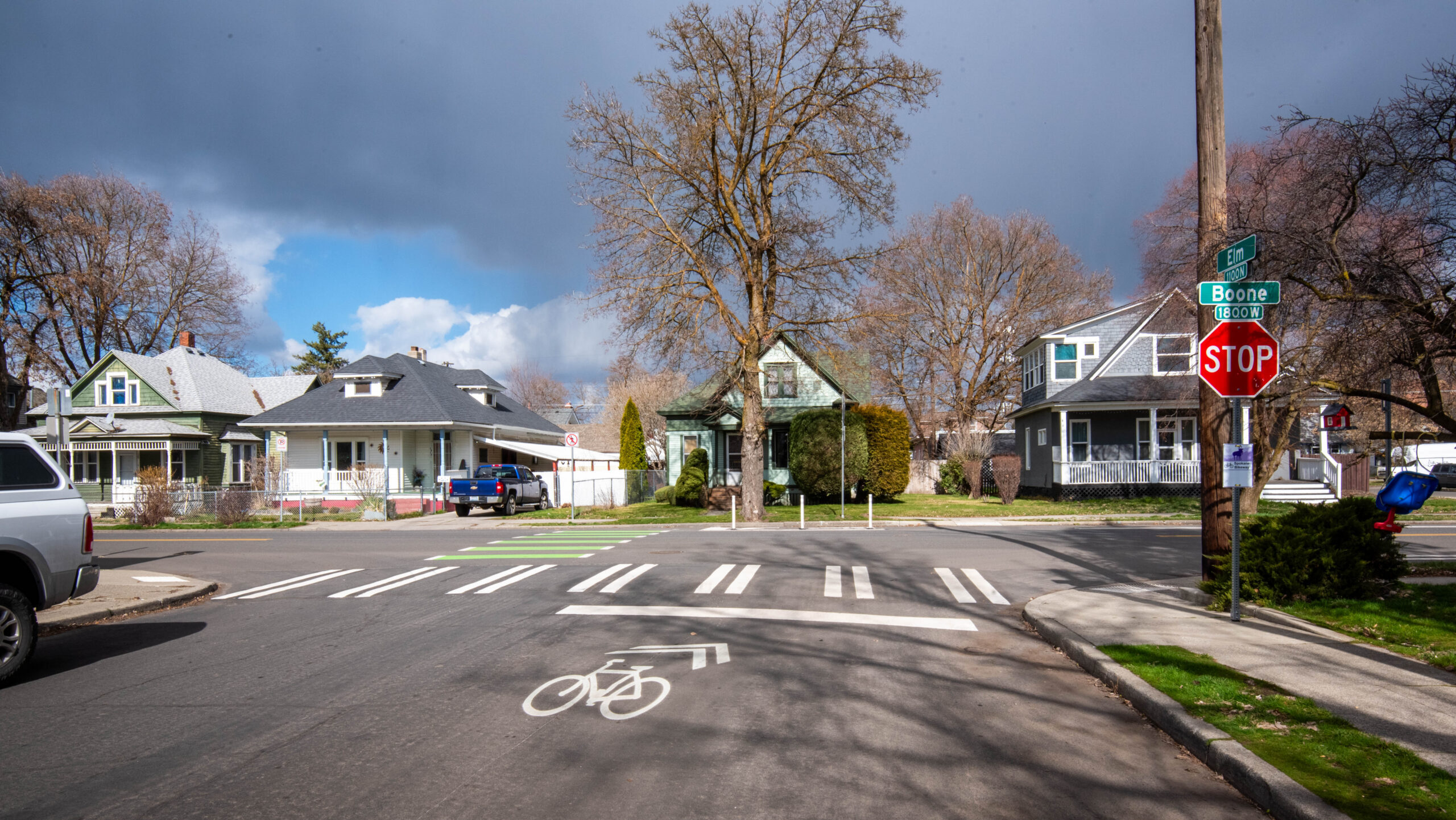 A street-level photo of an intersection. Pavement marking designates the travel lane as bicycle friendly.