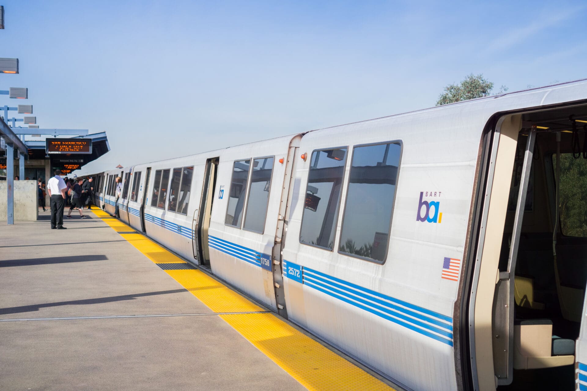 A BART train stops and opens its doors for passengers at a station’s platform in Oakland, California.