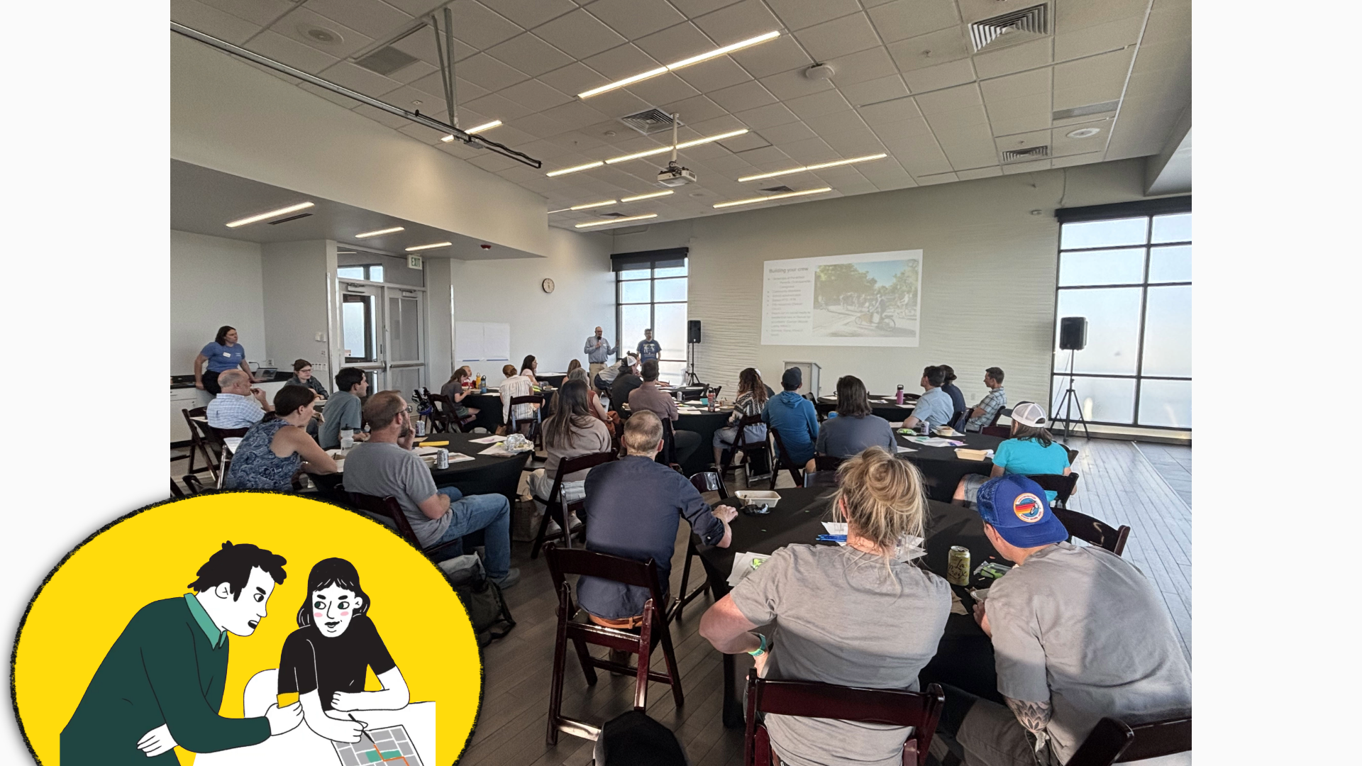 A photo of a room of adults watching a PowerPoint presentation.