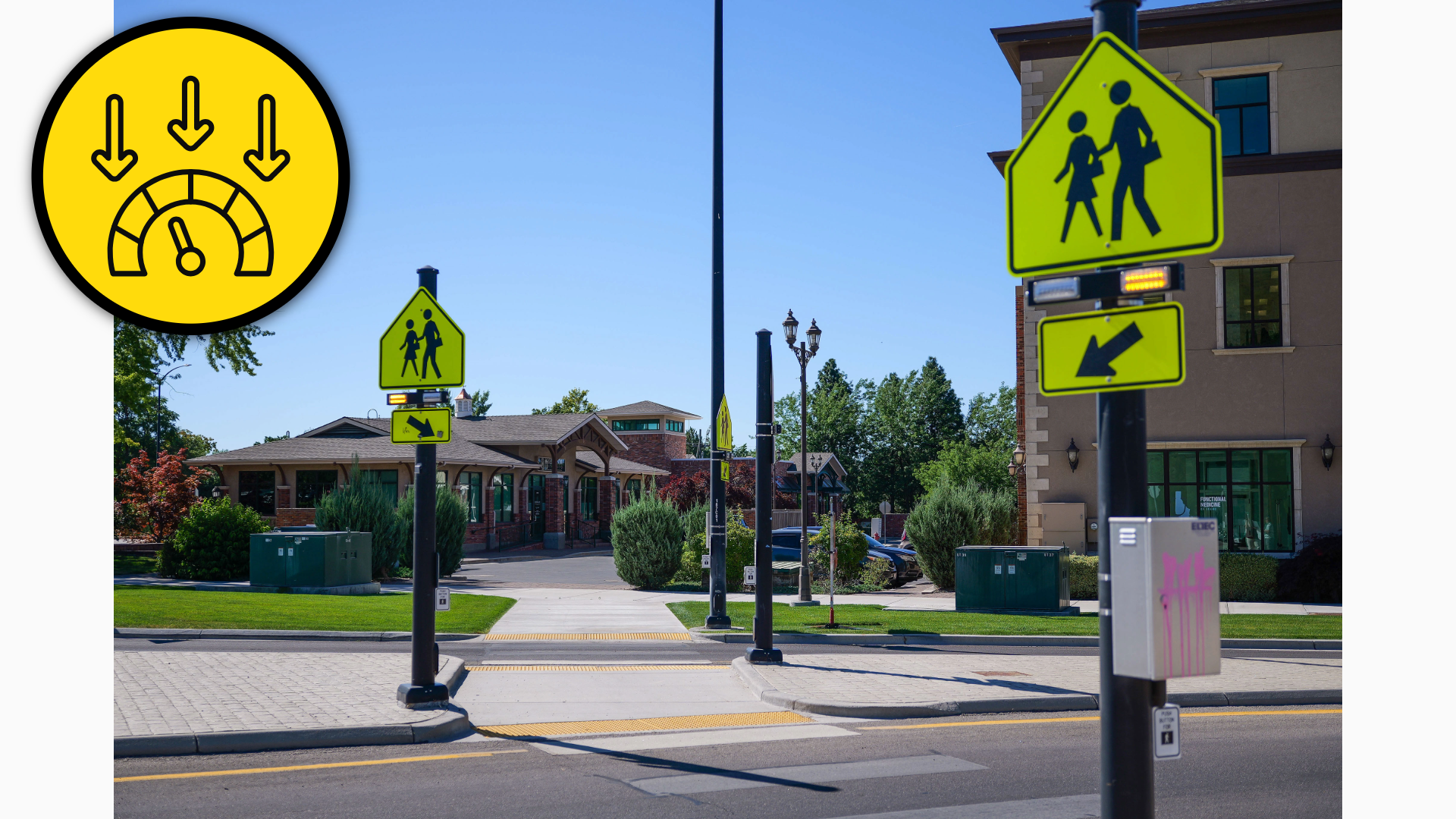 Photograph showing a city street pedestrian crossing near a school or community facility. Fluorescent yellow-green signs mark a child crossing and directional arrow, with curb ramp, tactile paving, utility boxes, trees, and buildings visible under clear blue sky.