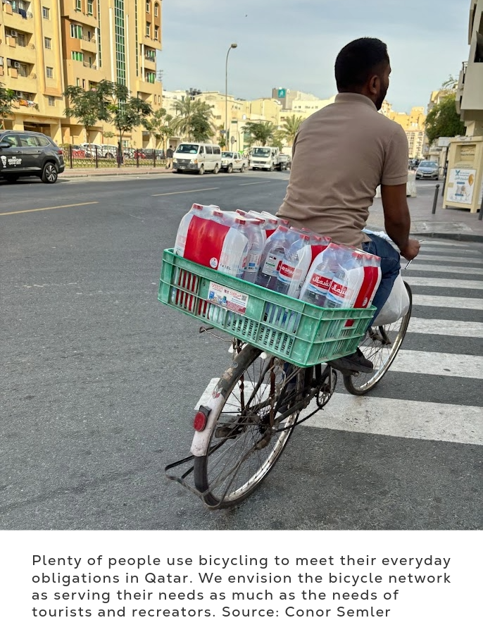 Street photograph showing a cyclist transporting multiple packs of bottled water in a green rear basket across a zebra crossing.